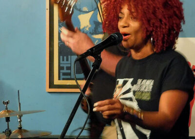 A woman with red afro hair singing