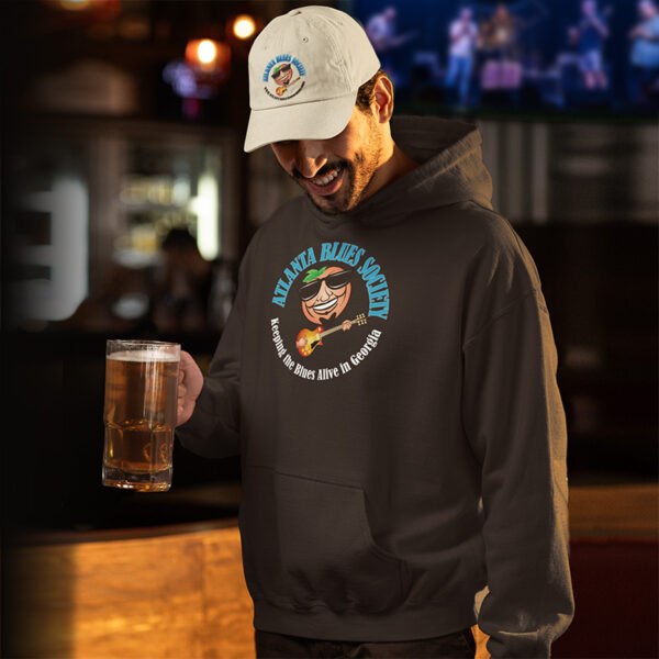 Man in a "Stars of the Blues" hoodie holding a beer glass in a bar setting.