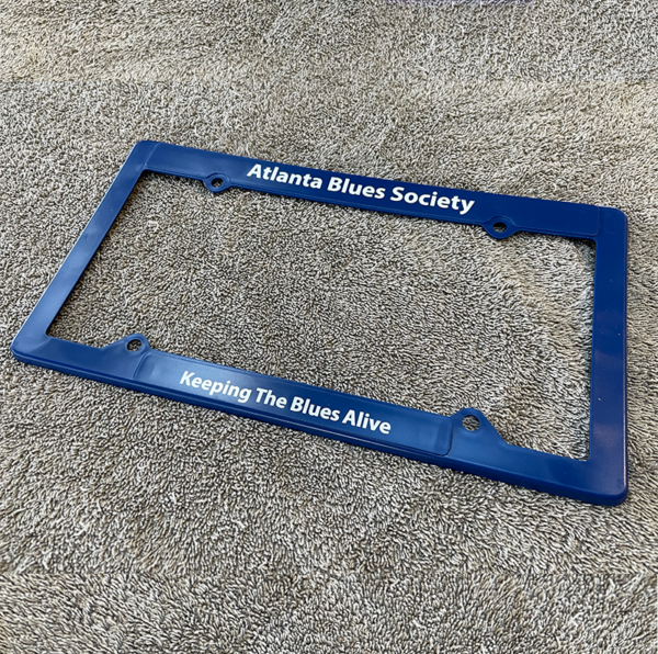 ABS License Plate Frame with "atlanta blues society" at the top and "keeping the blues alive" at the bottom, displayed on a textured background.