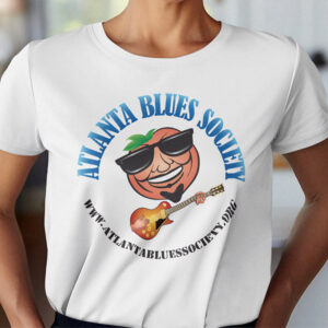 Woman wearing a white Georgia Blues T-shirt with the Atlanta Blues Society logo, featuring a cartoon peach playing a guitar.