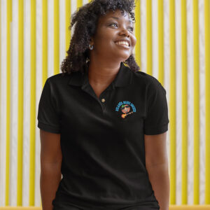 A smiling woman wearing a black polo shirt with a logo on the chest, sitting against a yellow striped background.